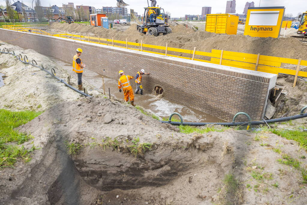 Water spuit uit nieuwe kademuur door gesprongen waterleiding