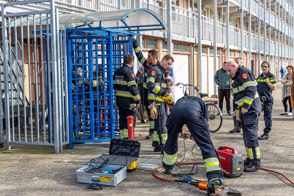 Kind met hoofd vast tussen draaideur