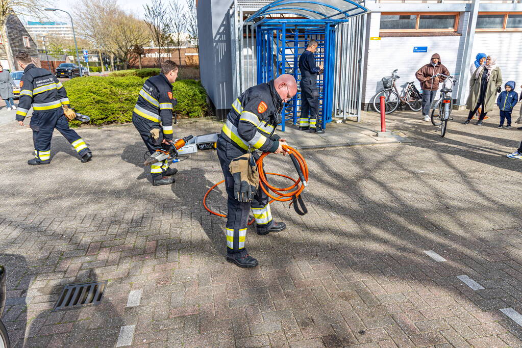 Kind met hoofd vast tussen draaideur