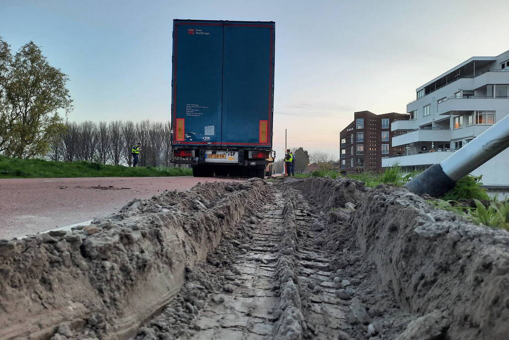 Vrachtwagen rijdt zich vast in berm