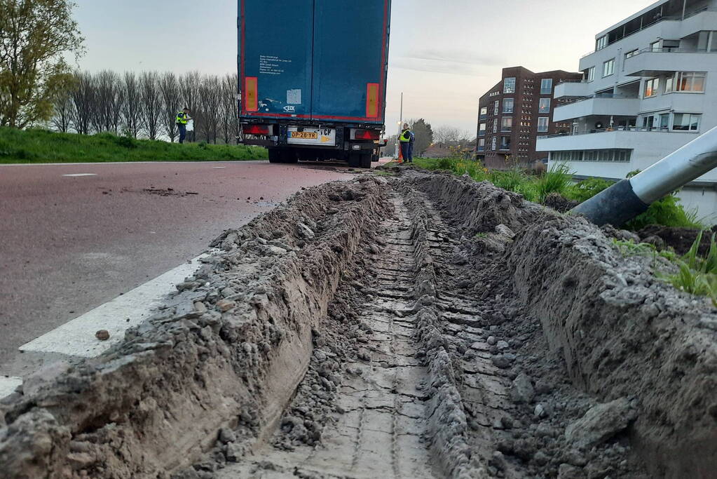 Vrachtwagen rijdt zich vast in berm