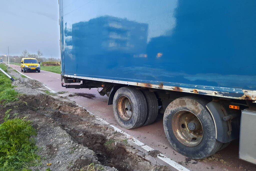 Vrachtwagen rijdt zich vast in berm