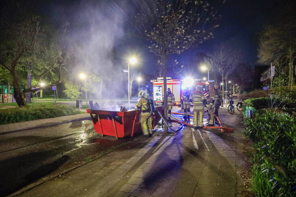 Vonken en rookontwikkeling bij brand in bouwafval container