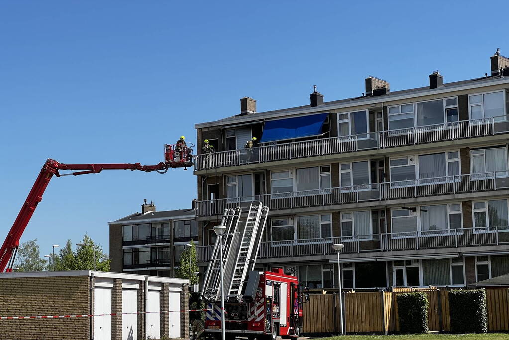 Dikke zwarte rookwolken uit de flatwoning
