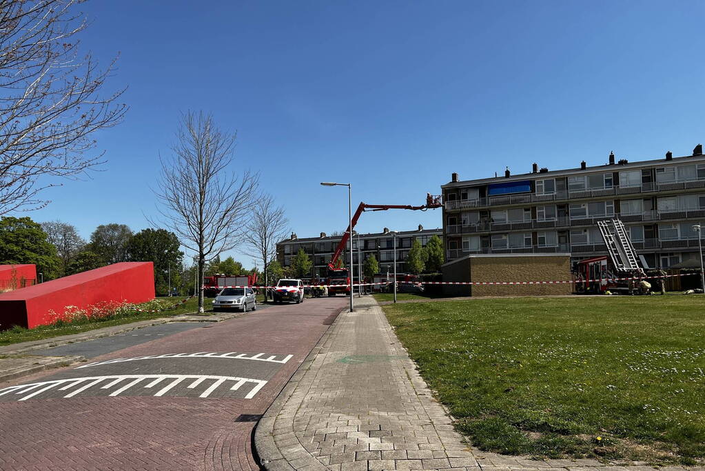 Dikke zwarte rookwolken uit de flatwoning