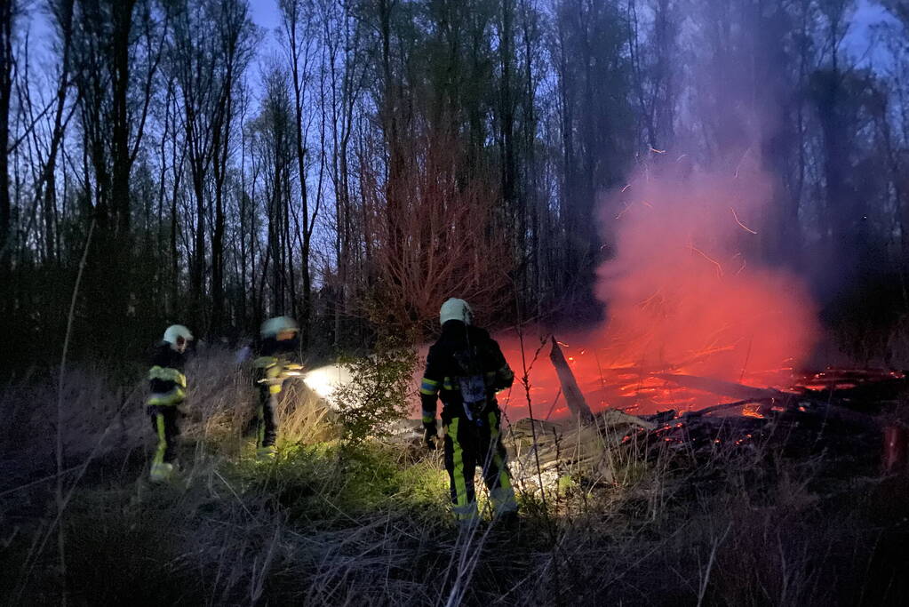 Stapel met hout vliegt in brand