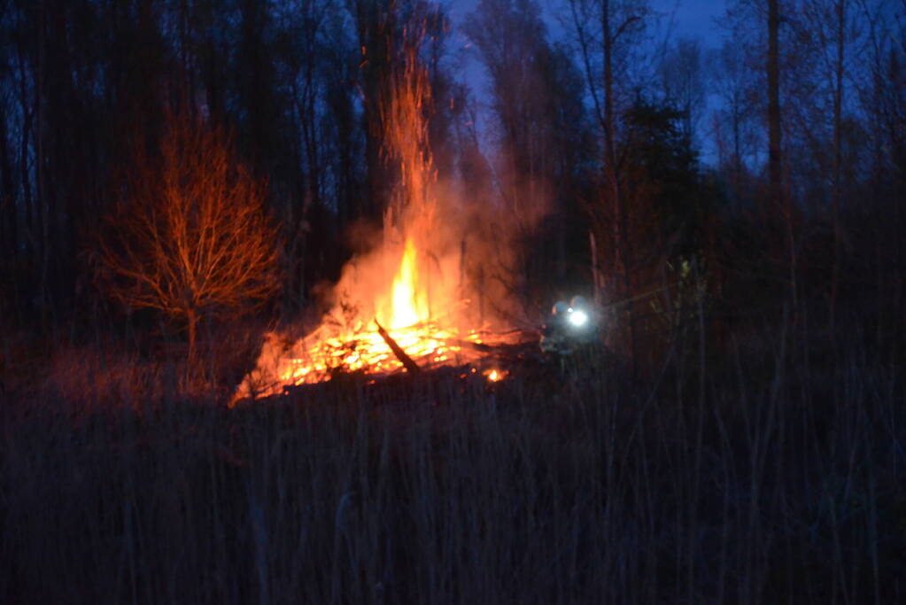 Stapel met hout vliegt in brand