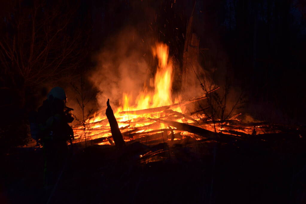Stapel met hout vliegt in brand