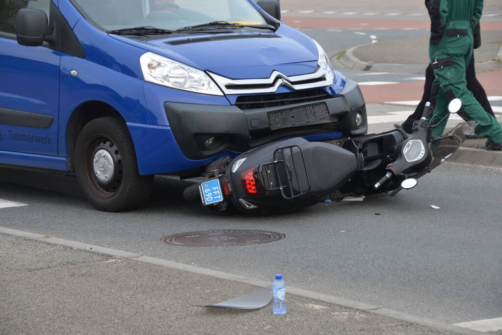 Scooter belandt onder bestelbus