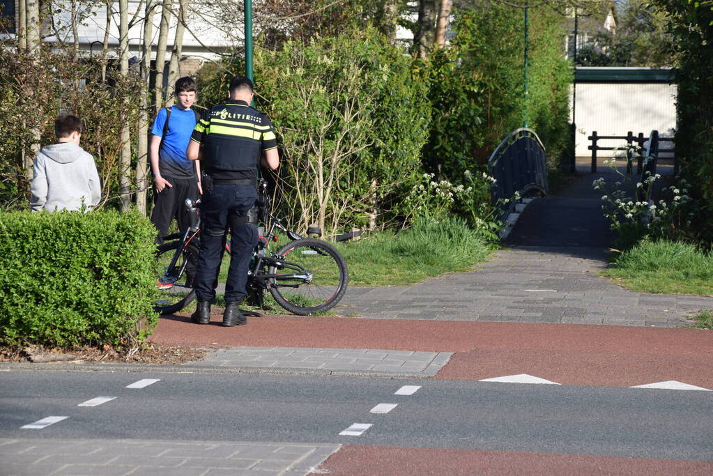 Jongeman op fiets vliegt over motorkap van auto