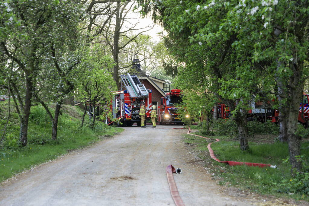 Vlammen slaan uit dak van vrijstaande woning