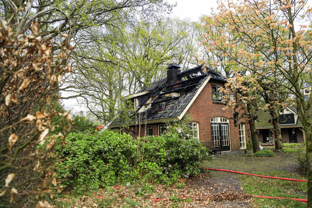 Vlammen slaan uit dak van vrijstaande woning