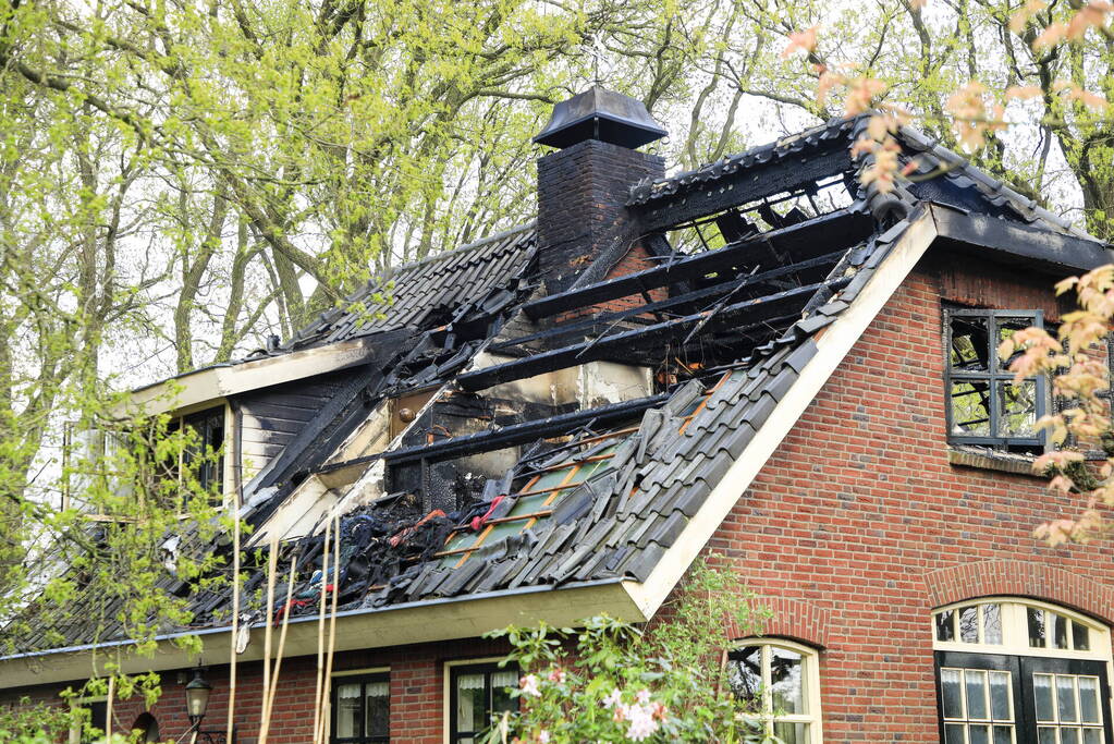 Vlammen slaan uit dak van vrijstaande woning