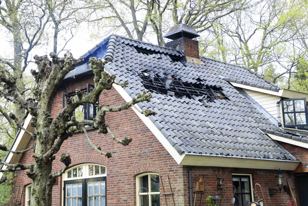 Vlammen slaan uit dak van vrijstaande woning