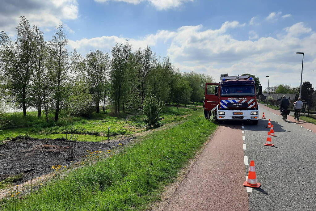 Stuk gras vlam gevat naast autoweg