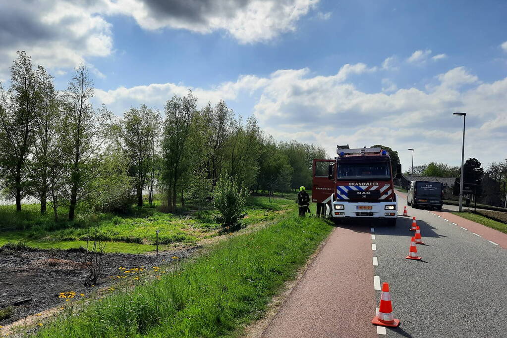 Stuk gras vlam gevat naast autoweg