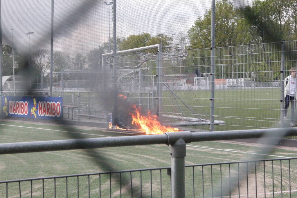 Vlammen bij brand naast sportveld