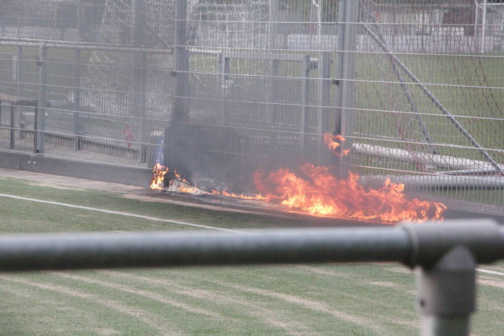 Vlammen bij brand naast sportveld
