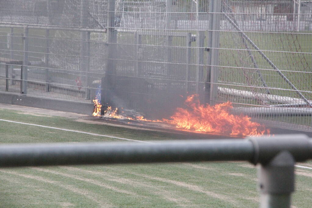 Vlammen bij brand naast sportveld