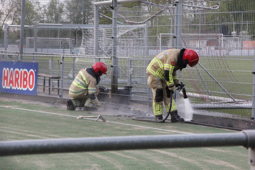 Vlammen bij brand naast sportveld
