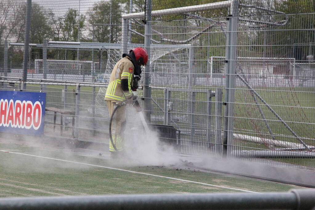 Vlammen bij brand naast sportveld