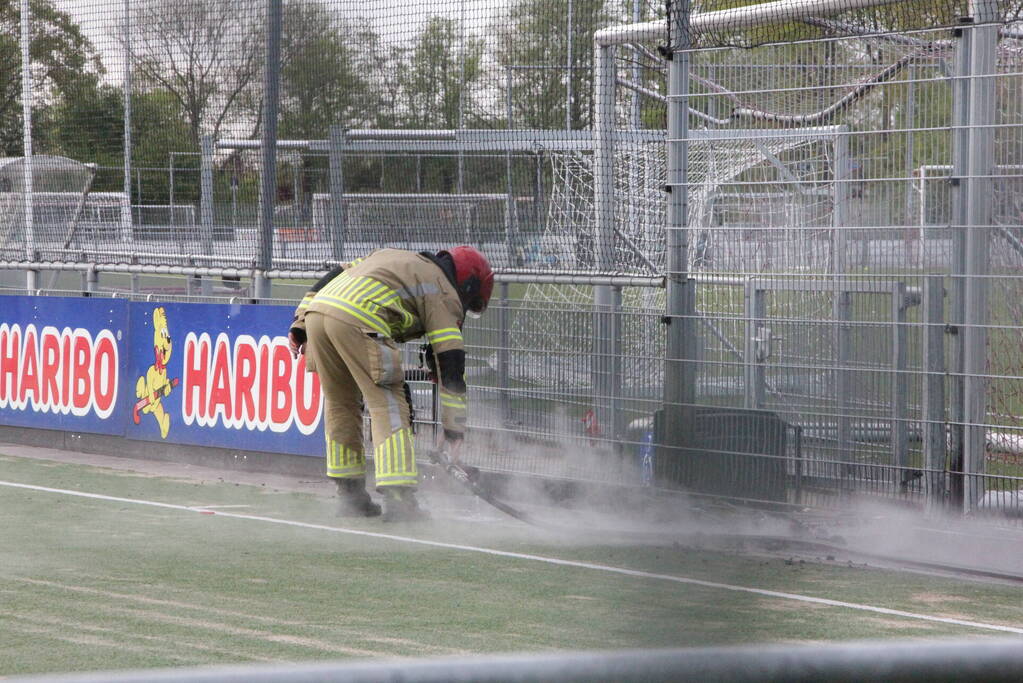Vlammen bij brand naast sportveld