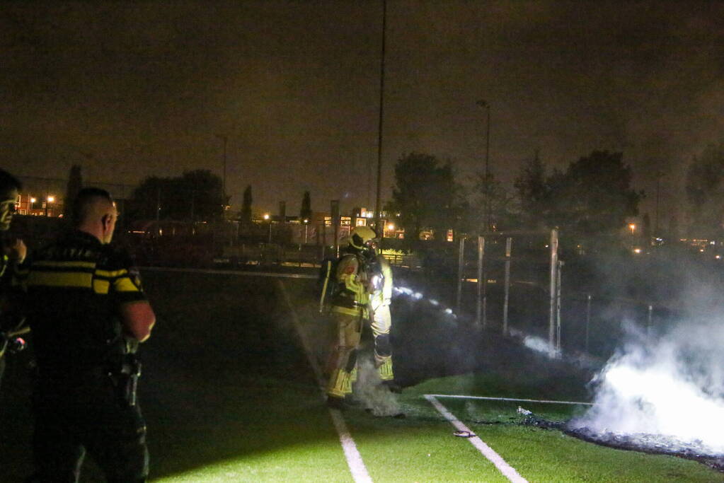 Vlammen op voetbalveld vanwege brand in afvalcontainer