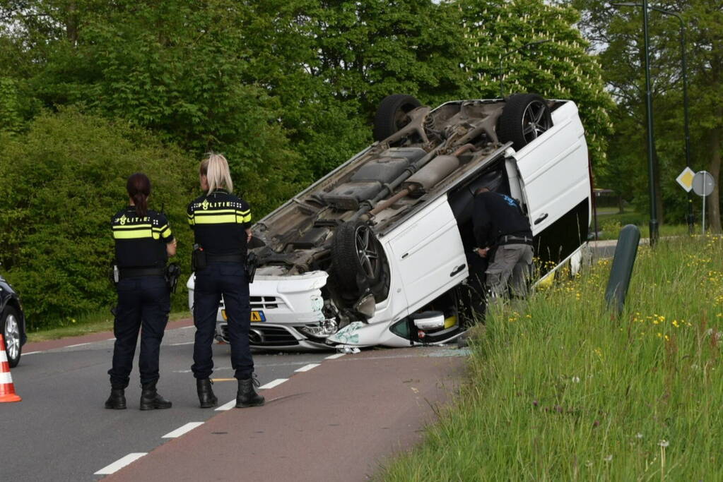 Bestelbus botst tegen paal en slaat over de kop