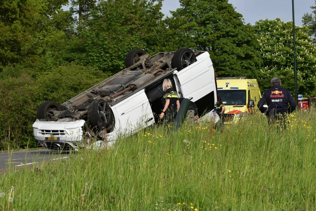 Bestelbus botst tegen paal en slaat over de kop