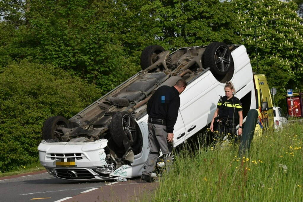 Bestelbus botst tegen paal en slaat over de kop