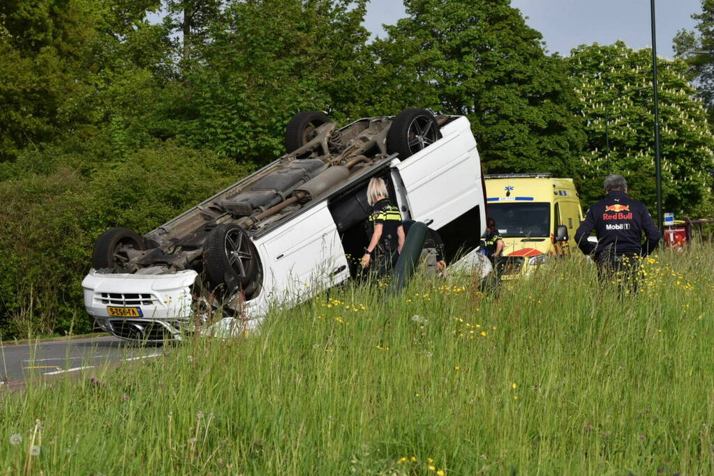 Bestelbus botst tegen paal en slaat over de kop
