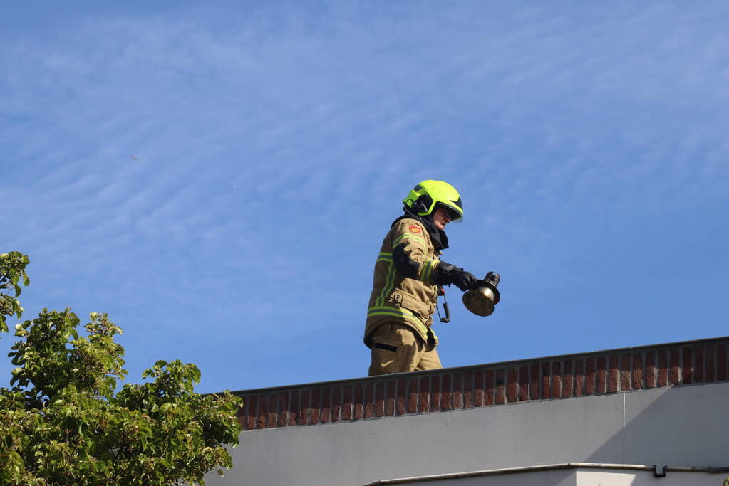 Brandweer veegt schoorsteen na brand