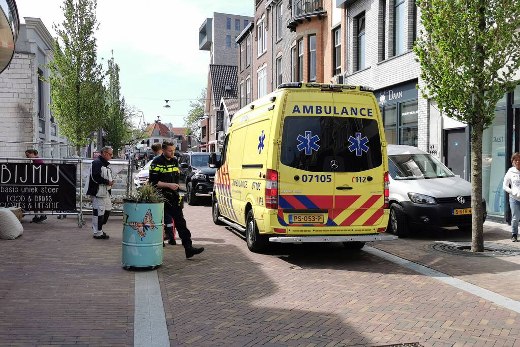 Voetganger aangereden door auto in winkelstraat