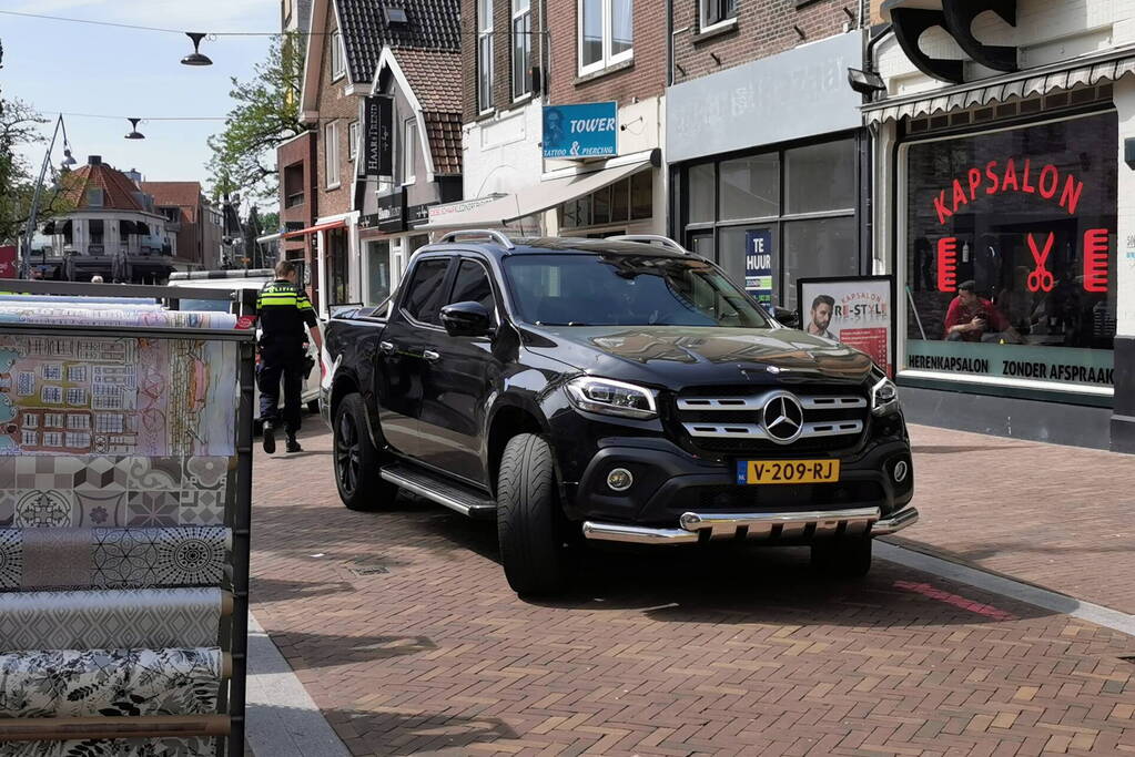Voetganger aangereden door auto in winkelstraat