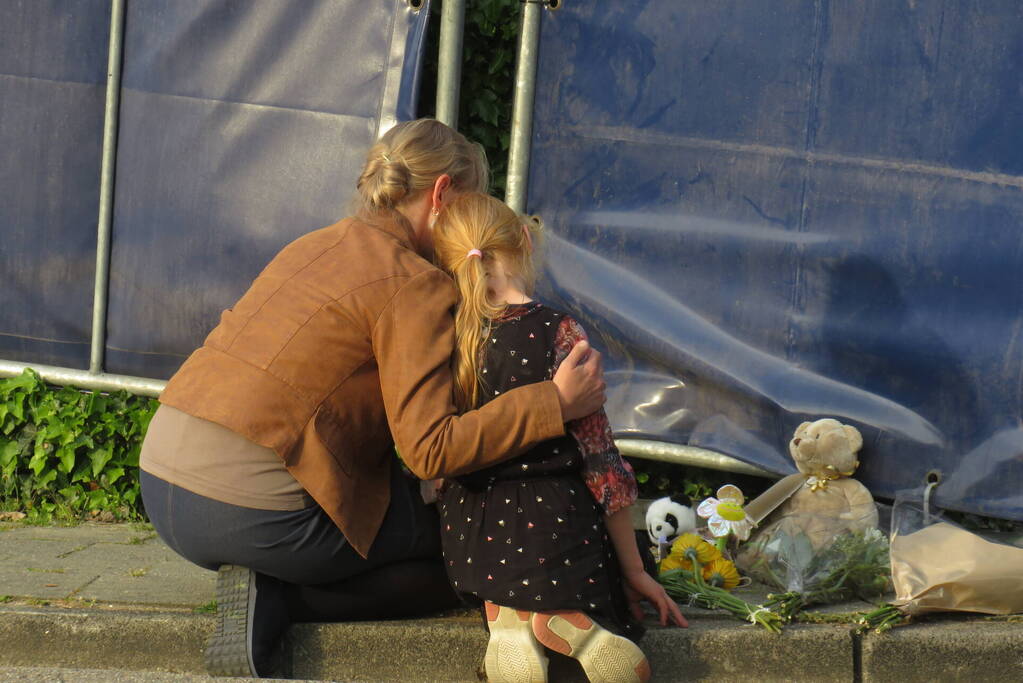 Bloemen en knuffels bij woning gezinsdrama