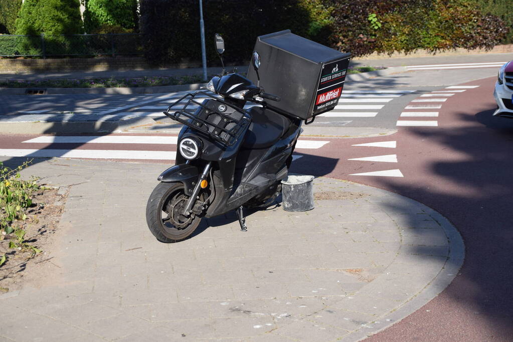 Maaltijdbezorger op scooter gaat hard onderuit