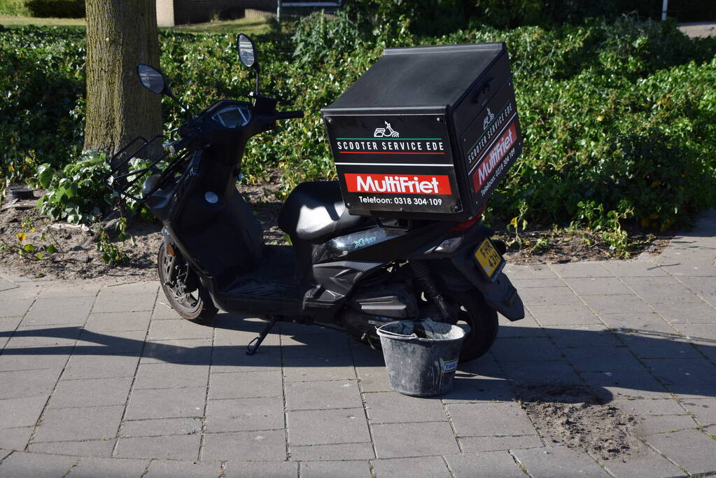 Maaltijdbezorger op scooter gaat hard onderuit