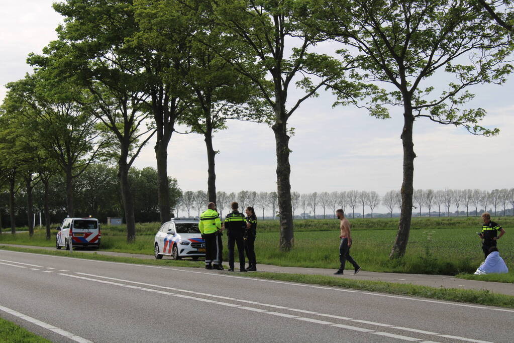 Personenauto raakt te water naast doorgaande weg