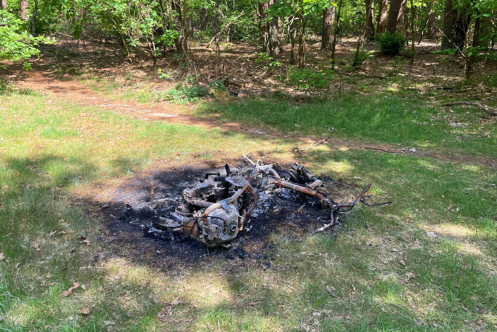 Onderzoek naar uitgebrande scooter in bosgebied