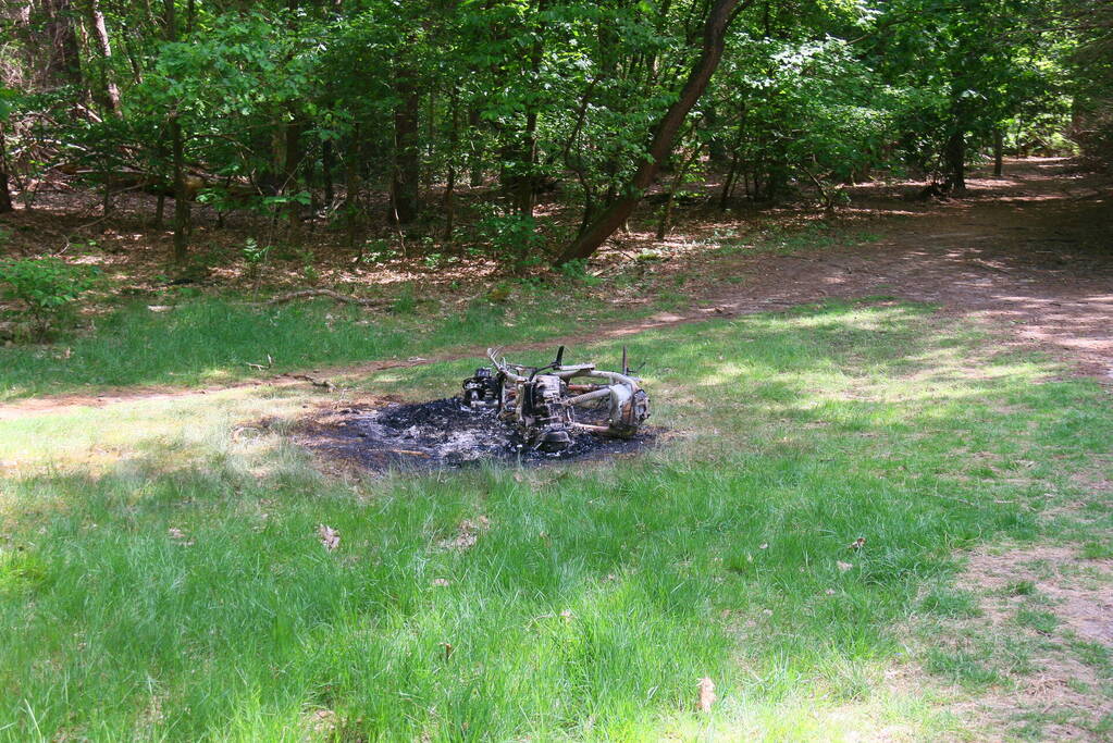 Onderzoek naar uitgebrande scooter in bosgebied