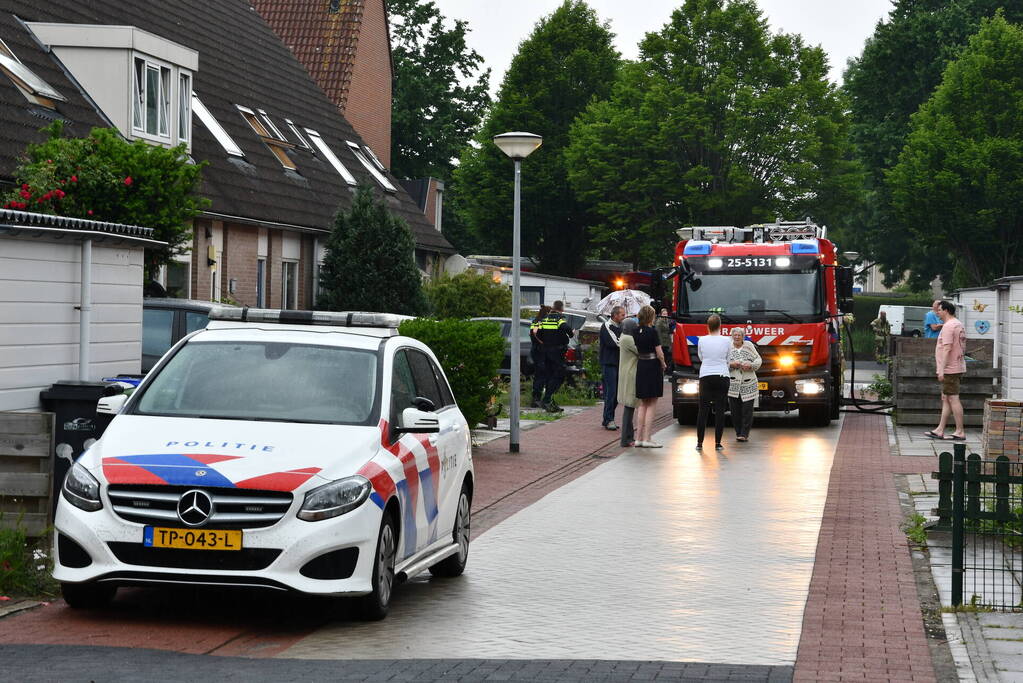 Veel rook uit zolderraam bij brand in woning