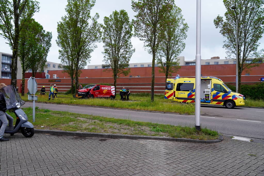 Bestuurder bestelbus bekneld na botsing tegen boom