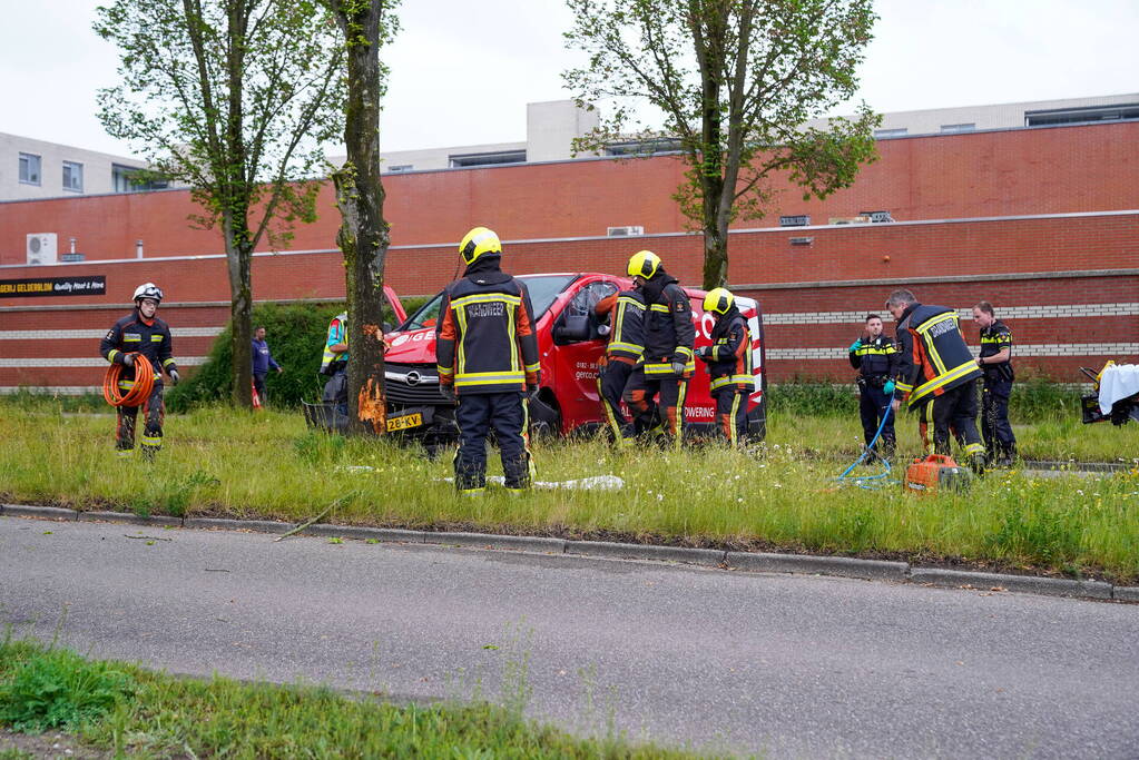 Bestuurder bestelbus bekneld na botsing tegen boom