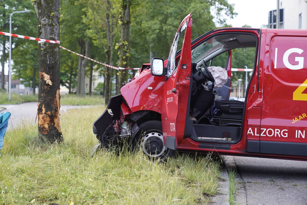 Bestuurder bestelbus bekneld na botsing tegen boom
