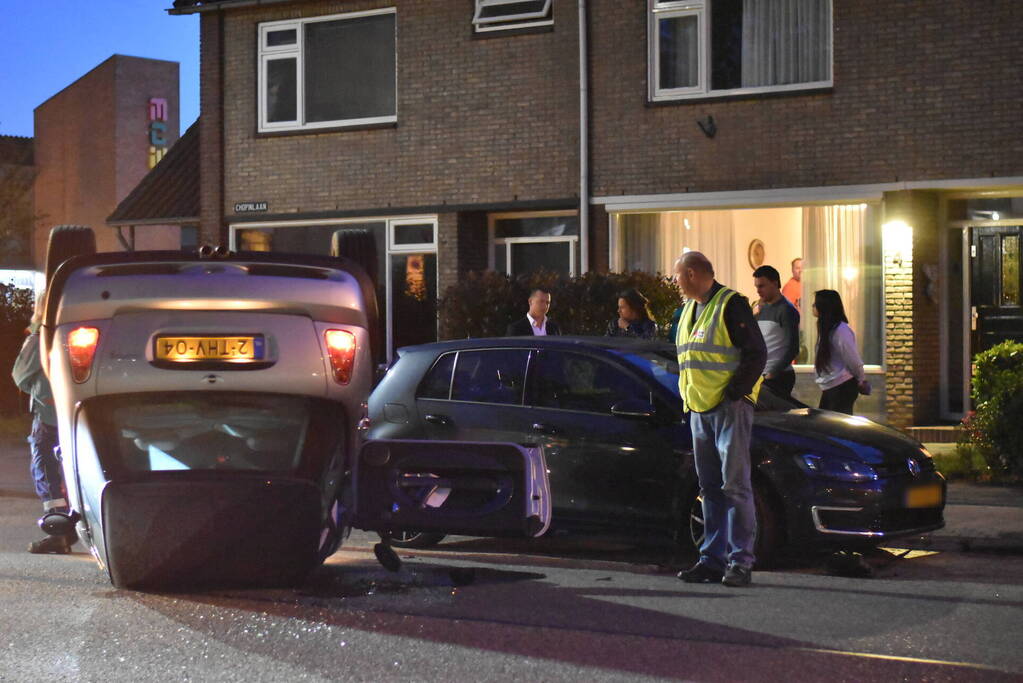 Auto op zijn kop na botsing met geparkeerde auto
