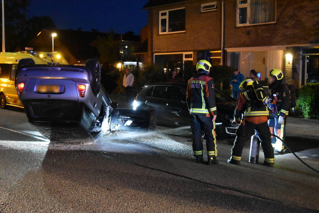 Auto op zijn kop na botsing met geparkeerde auto