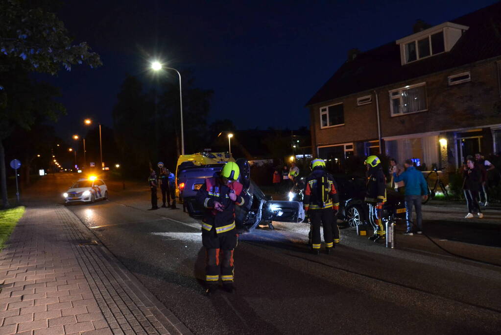 Auto op zijn kop na botsing met geparkeerde auto