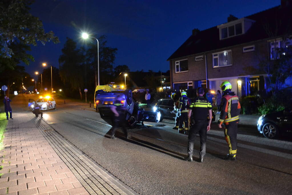 Auto op zijn kop na botsing met geparkeerde auto