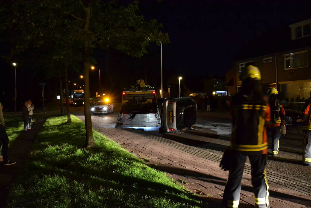 Auto op zijn kop na botsing met geparkeerde auto
