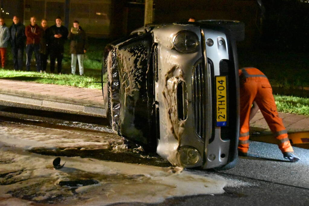Auto op zijn kop na botsing met geparkeerde auto